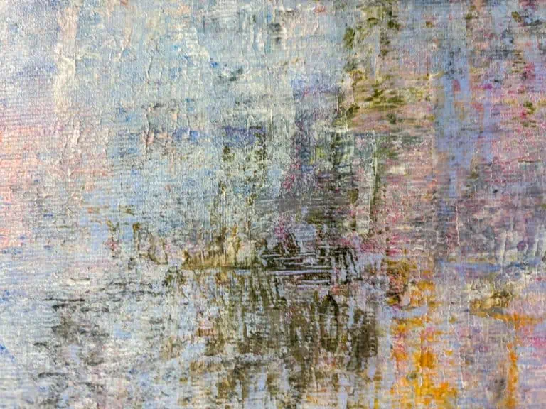 Abstraktes Gemälde in gedämpften Blau-, Rosa- und Ockertönen mit pastosem Farbauftrag. Senkrechte und horizontale Pinselstriche erzeugen eine flimmernde, atmosphärische Textur, die an ein Spiegelbild von Bäumen und Vegetation in einem stillen Gewässer erinnert. Werk von Carolina Strauch in der Ausstellungsreihe „Dental meets Art" in der Praxis Baumstark zu sehen.